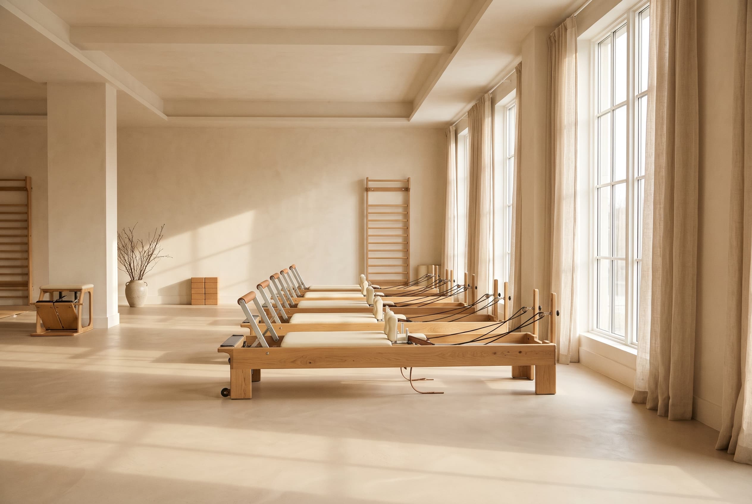 Minimalist Pilates studio with oak equipment and soft morning light